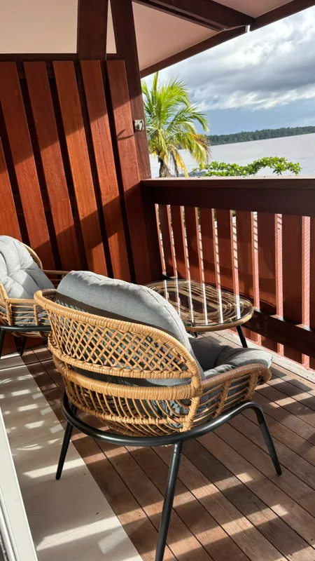 Fauteuils sur un balcon en bois face au Maroni