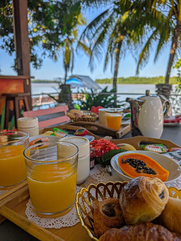 Petit-déjeuner servi face au fleuve : jus d'orange, papaye, viennoiseries
