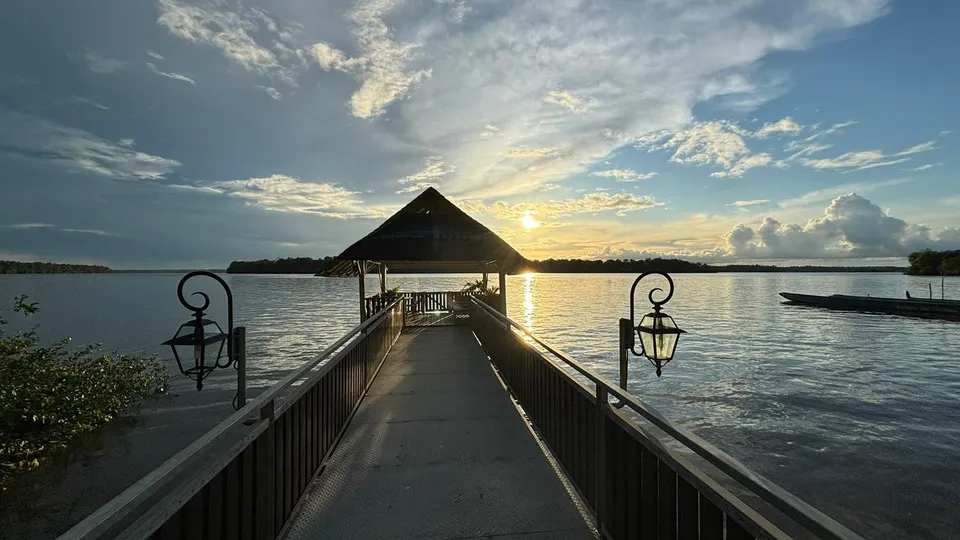 Ponton en bois s'avançant sur le Maroni au coucher du soleil, avec un kiosque au bout